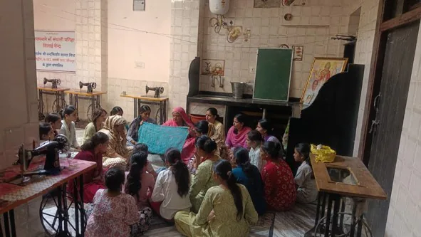 सिलाई केन्द्र में प्रशिक्षण प्राप्त करती महिलाएँ